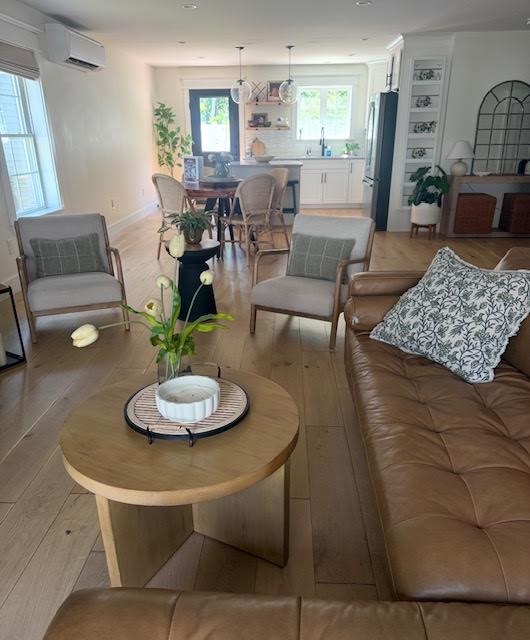 Open living and dining area with light oak floors