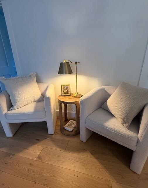 Two boucle armchairs with a brass reading lamp